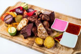 Plate of four meats and grilled vegetables